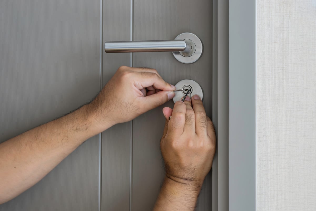 locksmith try to open the door by screwdriver